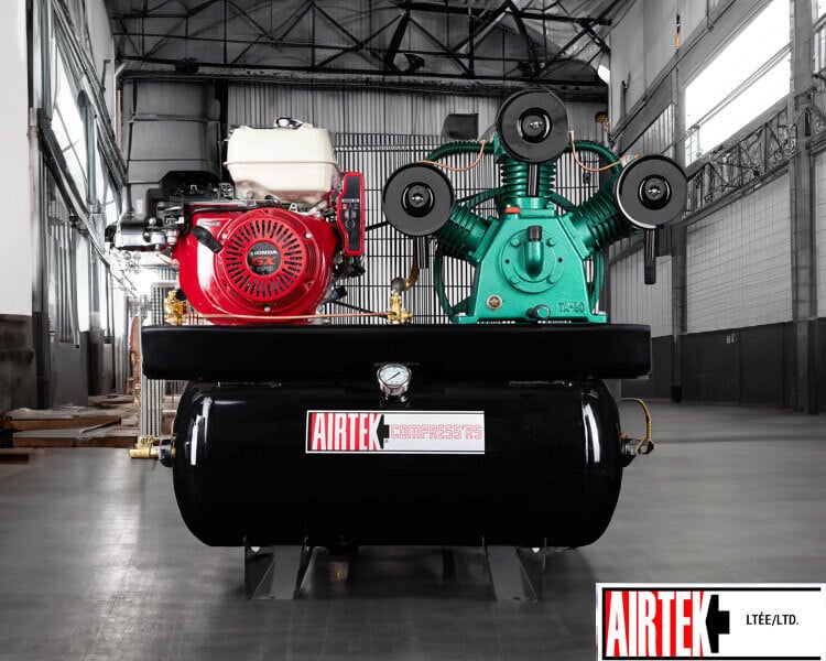Compresseur d’air industriel Airtek robuste avec moteurs rouge et vert, positionné dans un grand entrepôt.