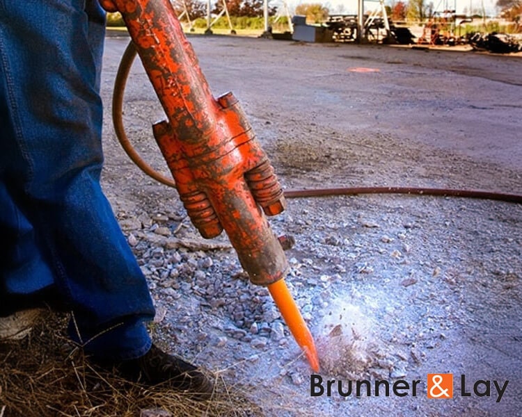 Outil de démolition Brunner en gros plan, utilisé pour briser du béton sur un chantier de construction.