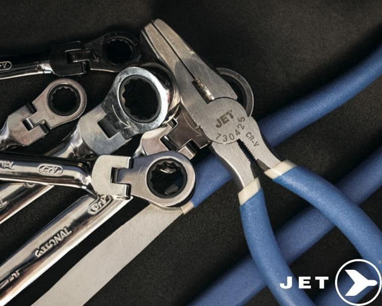 Collection de clés métalliques JET Tools de différentes tailles, disposées sur une surface sombre avec tuyaux bleus, soulignant leur durabilité.