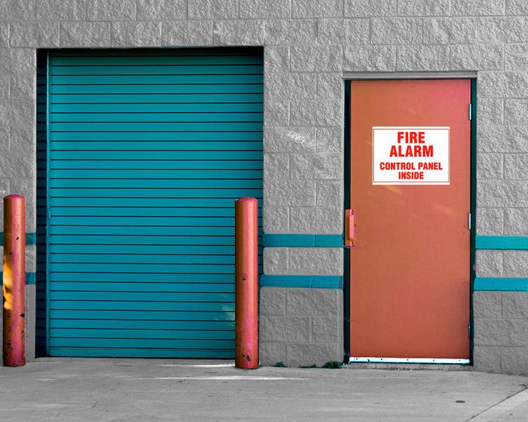 Panneau d'alarme incendie sur une porte, essentiel pour la sécurité incendie et la gestion des urgences.